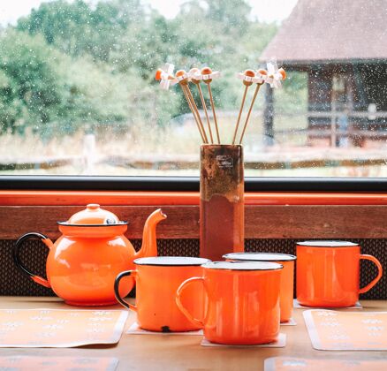 马克杯雨天 杯子和茶壶在窗前鲜花旁茶壶公寓晚餐