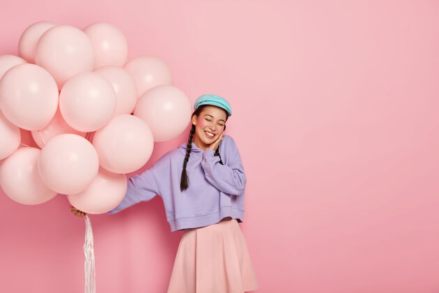 时尚欣喜若狂的日本女子闭上眼睛 欣然接受成功的祝贺大学 捧着气球气球复制空间裙子