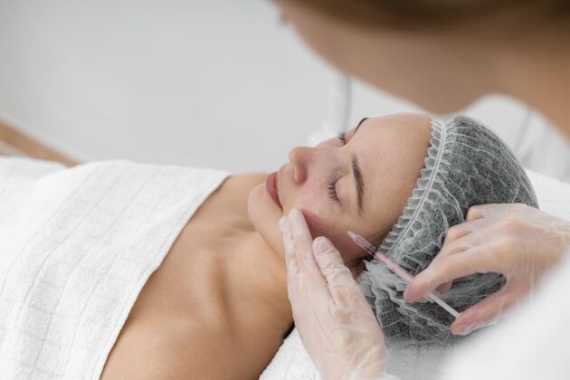 治疗美容师在给女性客户注射填充物美容治疗美容治疗美容护理