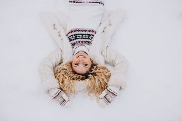 寒假躺在公园雪地上的年轻女子漂亮成人欢呼