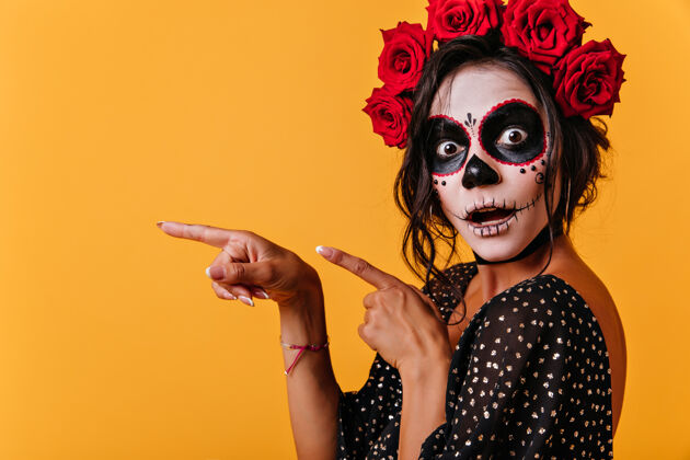 传统穿着万圣节服装的晒黑女模张大嘴巴摆姿势穿着墨西哥传统服装的漂亮女孩庆祝死亡日女巫女性可怕