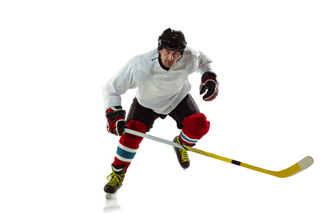 运动性格年轻的冰球男运动员 冰球场上有棍子 白墙运动员戴着器械和头盔练习运动的概念 健康的生活方式 运动 运动 动作男性溜冰年轻