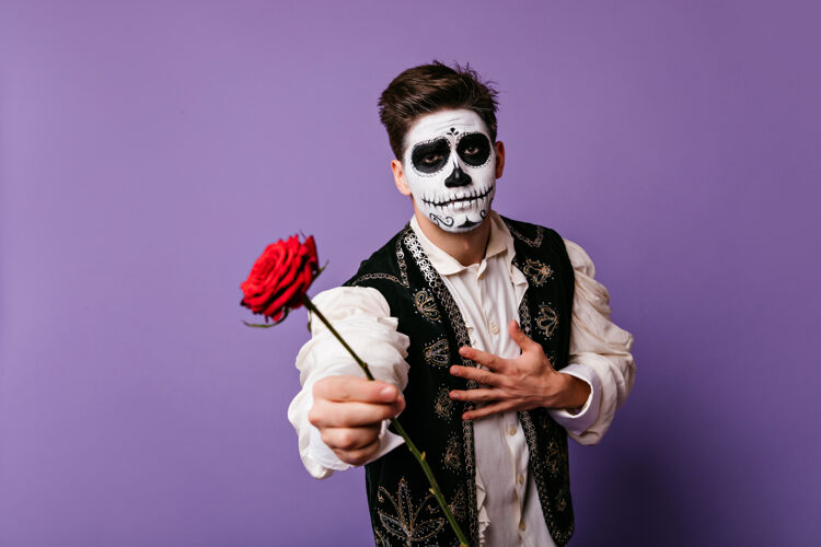 骷髅一个墨西哥人拿着一朵红花 化着墨西哥人的死妆穿着传统西班牙服装的感性男人传统室内恐怖