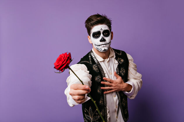 骷髅一个墨西哥人拿着一朵红花 化着墨西哥人的死妆穿着传统西班牙服装的感性男人传统室内恐怖