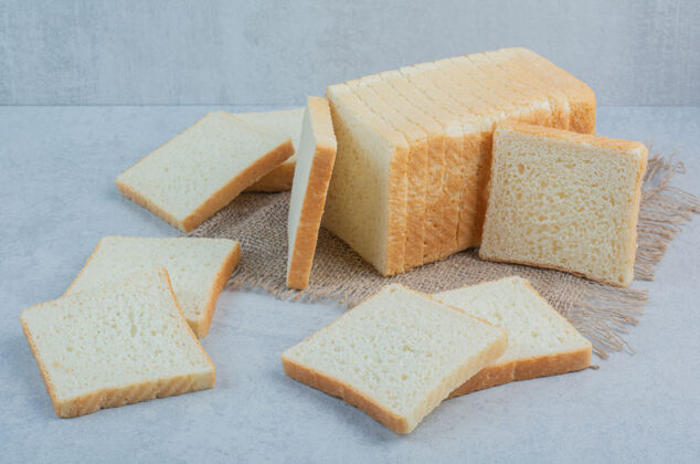 吐司新鲜的烤面包片放在粗麻布上高质量的照片新鲜麦片切片