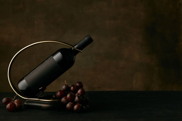 酒精美味葡萄的正面图一盘葡萄和酒瓶在黑暗中美味石头葡萄