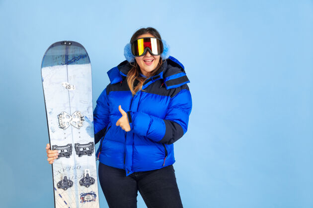 成功滑雪板蓝色空间上的白种女人肖像穿着暖和衣服的漂亮女模特女性工作面部
