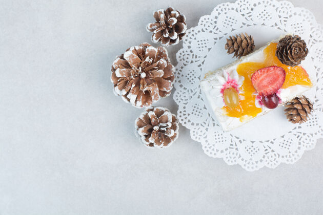 食品一块美味的蛋糕与松果在白色的背景高品质的照片面包房蛋糕盘子