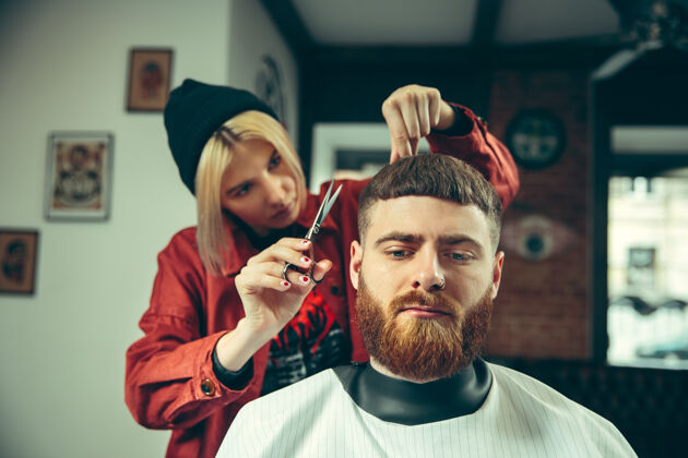 剃须客户在理发店剃须女理发师在沙龙性别平等时尚女性男人