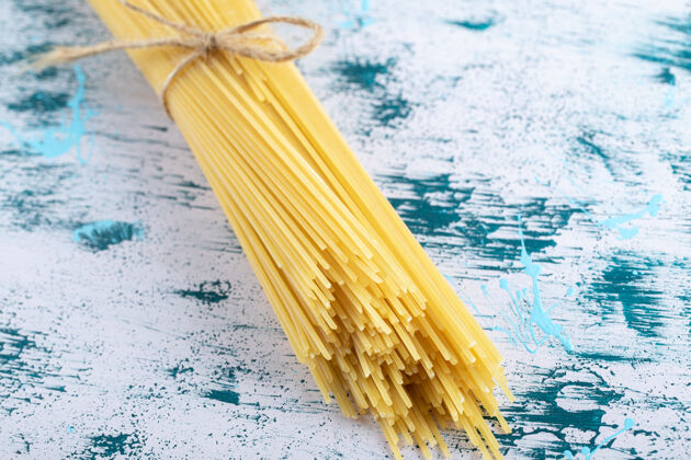 意大利面生面用绳子绑在五颜六色的面上烹饪生的通心粉