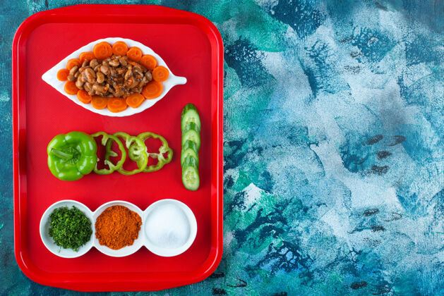 顶视图把胡萝卜 豆子和蔬菜放在盘子里 放在蓝色的盘子里胡椒蔬菜风味