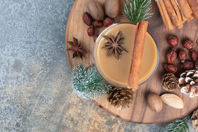 松果一杯咖啡 肉桂棒和松果放在木盘上高质量的照片肉桂干的饮料