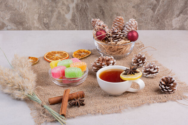 杯子甜甜的糖果和美味的茶在麻布上高品质的照片棍子红球水果