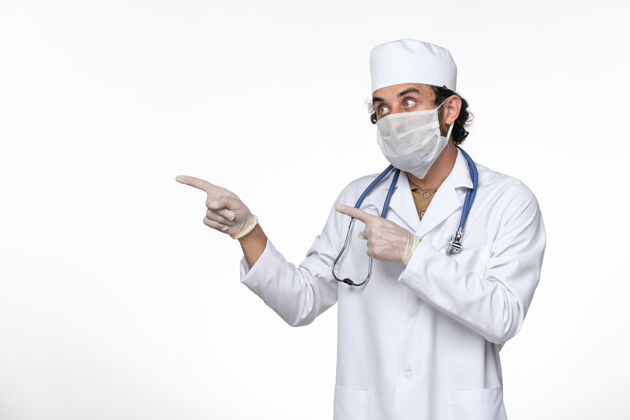 大流行正面图穿着医疗服的男医生戴着无菌口罩 以防白墙病毒感染病毒性疾病实验室外套疾病冠状病毒