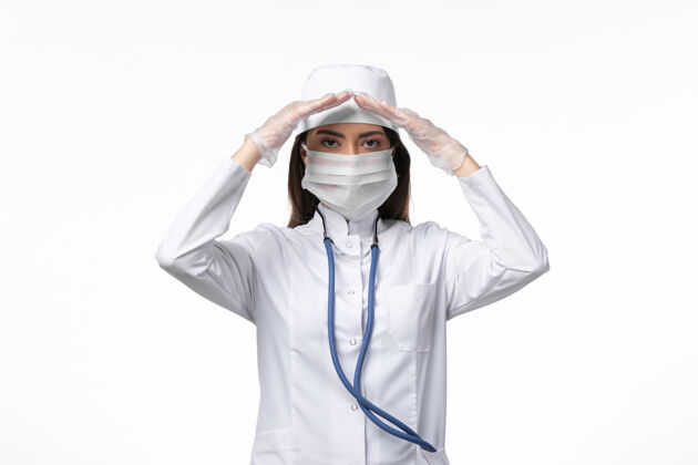 姿势正面图女医生身穿白色无菌医疗服 带口罩 因冠状病毒在白墙上摆病-大流行病毒病冠状病毒医生女性