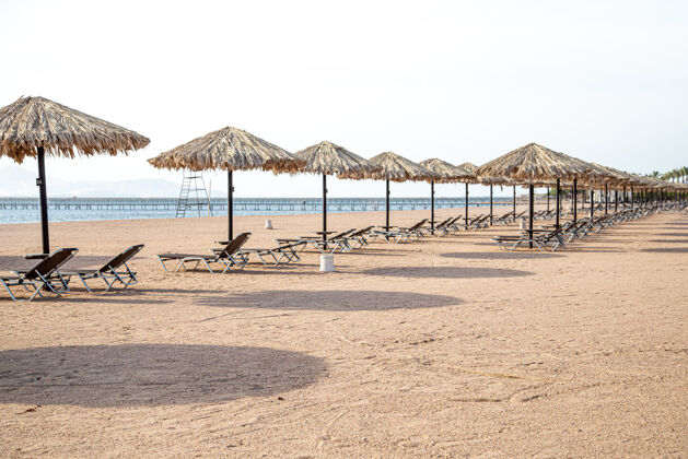 空旷空荡荡的海滩 阳光懒汉和雨伞检疫期间的旅游危机地中海海岸海洋