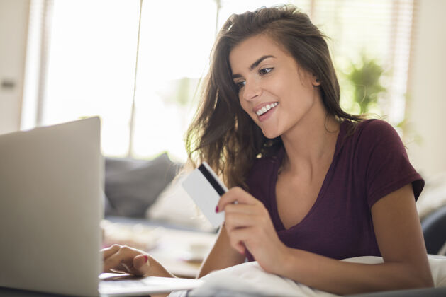 忙碌女人用笔记本电脑在网上购物网上购物更方便快捷面部表情女人日光