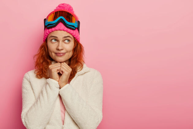 梦幻漂亮活泼的女人有梦幻般的表情 戴着粉色的帽子和滑雪镜 复制空间冬天粉色旁白