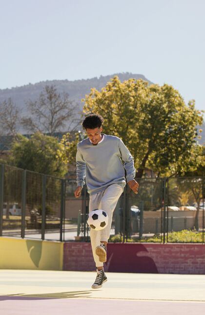 足球运动员一个正在踢足球的年轻人年轻人体育男