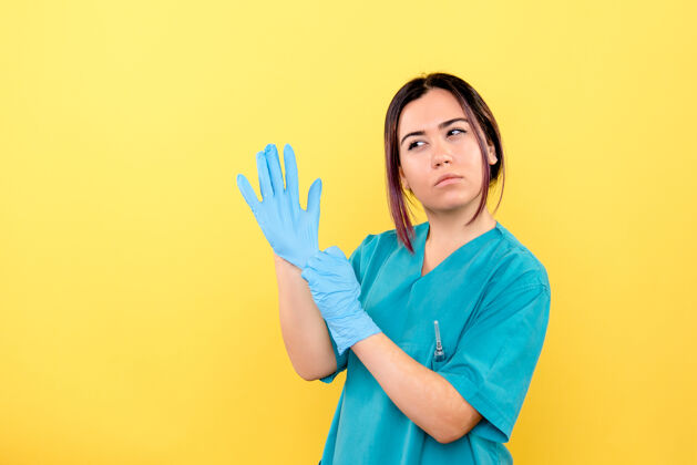 人戴着手套的医生的侧视图警告人们有关冠状病毒大流行成人人警告