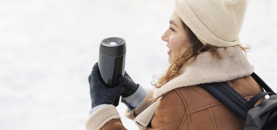徒步旅行特写拿着热水瓶的女人冬季水平背包