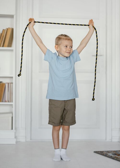 垂直满脸笑容的男孩拿着跳绳健康运动锻炼