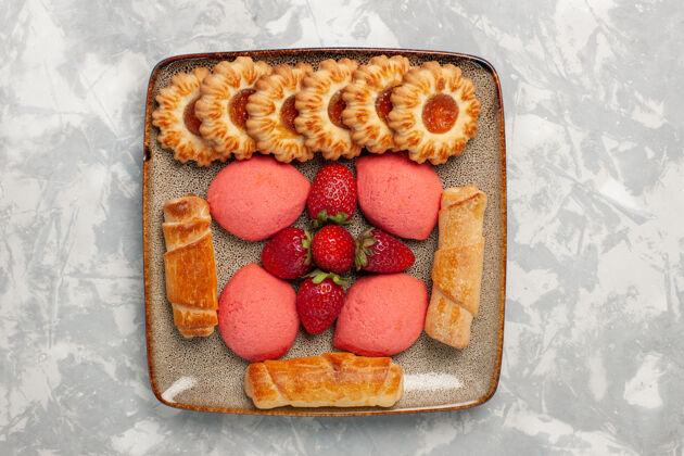 浆果俯瞰美味的百吉饼蛋糕草莓和饼干在白色的表面可食用水果饼干美味