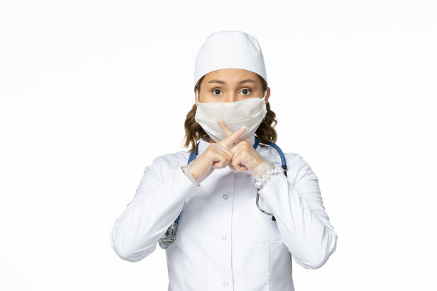 口罩正面图年轻女医生戴着无菌口罩和手套由于白色表面有冠状病毒疾病到期医生
