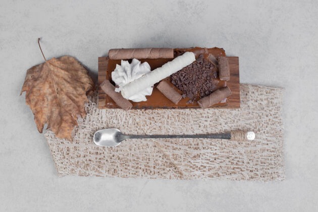 巧克力在大理石桌上用叶子和勺子切巧克力蛋糕高质量的照片新鲜甜点粗麻布