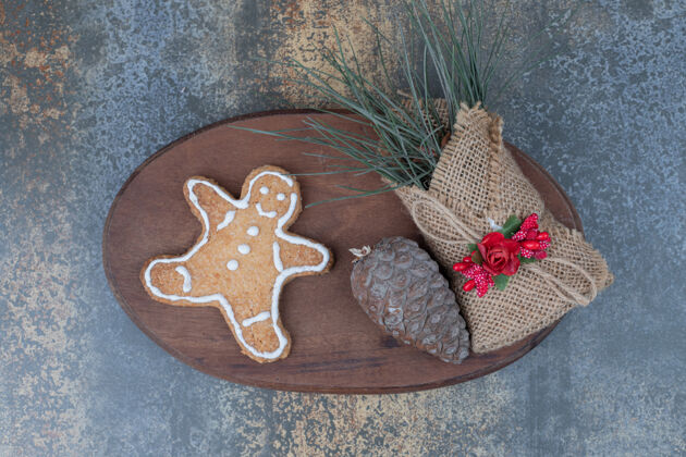 圣诞节姜饼人饼干 松果和草在粗麻布在木板上高品质的照片饼干姜美味