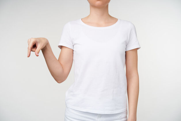 翻译摄影棚拍摄的年轻女性穿着白色t恤 在学习聋哑字母表时用手指显示字母q 与白色背景隔离手年轻人T恤