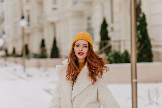 年轻性感的姜女在模糊的街道上摆姿势白种人美丽的女孩享受冬天欧洲雪季节