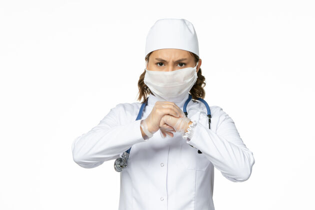 大流行正面图年轻女医生由于白色表面有冠状病毒 戴着无菌口罩和手套药品专业人员冠状病毒