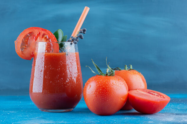 自然一杯番茄汁和两片番茄在蓝色背景上高质量的照片有机农业收获