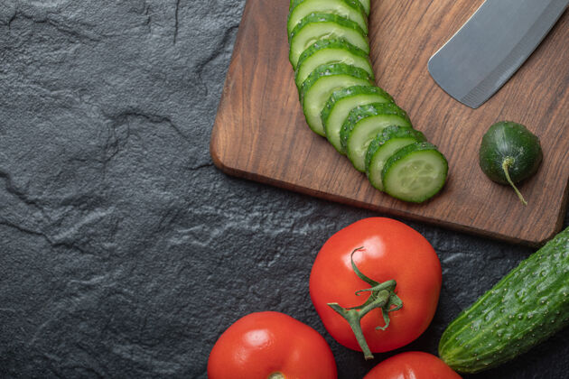 料理黑色背景上的黄瓜片和西红柿片高质量的照片饮食木头木板