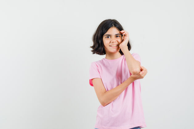 粉色小女孩站在思考的姿势在粉红色的t恤衫 看起来很高兴 前视图可爱高兴思考