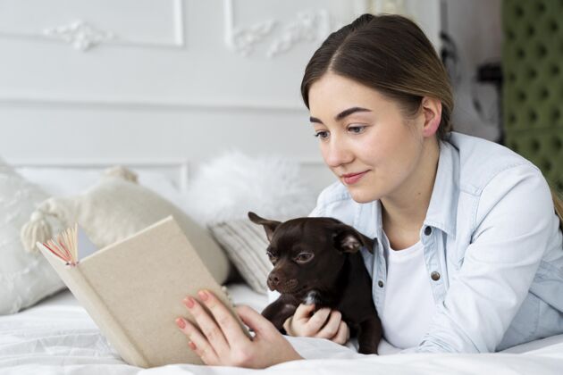 特写特写女孩和狗在床上看书责任宠物青少年