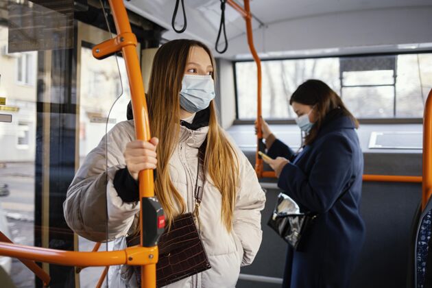 社会距离在公共交通工具上戴口罩的人口罩冠状病毒外科口罩