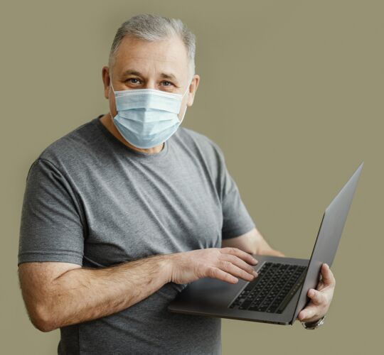 休闲带着口罩的胡子男人拿着笔记本电脑男性笔记本电脑成人