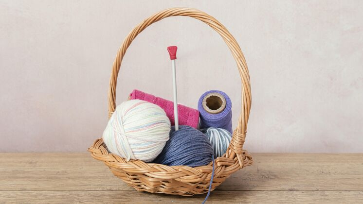 编织工篮子里有羊毛和针织针针织针纹理纺织品