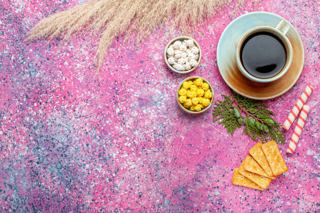 图案顶视图一杯茶 粉红色表面有饼干和糖果杯生的彩色