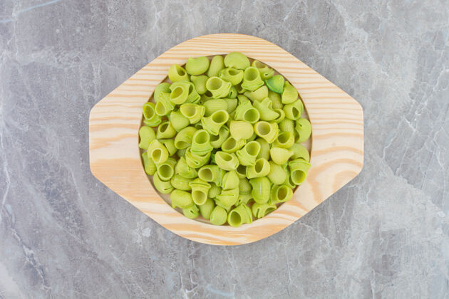 膳食在一个圆形的木制盘子里放上绿色的自制意大利面餐厅中美味