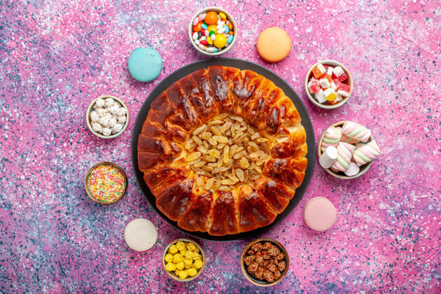 视图顶视图五颜六色的法国马卡龙小美味蛋糕与糖果和葡萄干馅饼淡粉色桌糖烤饼干饼干蛋糕馅饼茶蛋糕糖茶