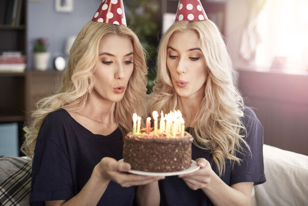 情绪美丽的双胞胎庆祝生日微笑两个人甜点