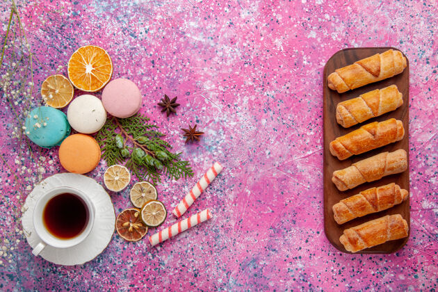 杯子顶视图一杯茶 配上五颜六色的法国马卡龙和百吉饼 粉色桌上蛋糕饼干糖甜饼茶饼干糖果百吉饼顶部