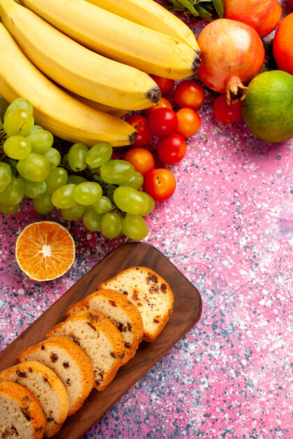 美味俯瞰美味的水果组成与切片蛋糕在粉红色的办公桌上顶部生的成分