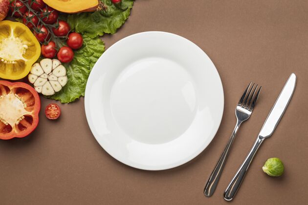 顶视图用盘子和餐具把有机蔬菜放平生物素食主义者有益