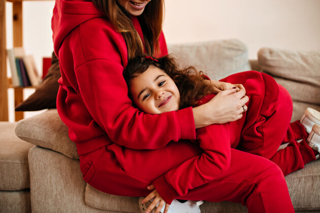 女士笑妈妈抱着女儿在家的剪影笑孩子和妈妈玩的室内镜头在一起微笑积极