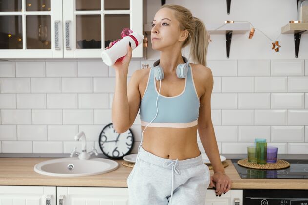 耳机锻炼后喝水的女人女人运动服设备