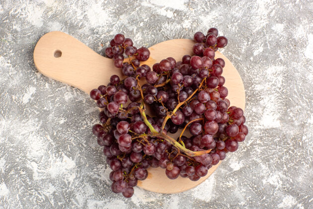 甜顶视图新鲜的红葡萄醇厚多汁的水果在浅白色的表面新鲜葡萄酒醇厚